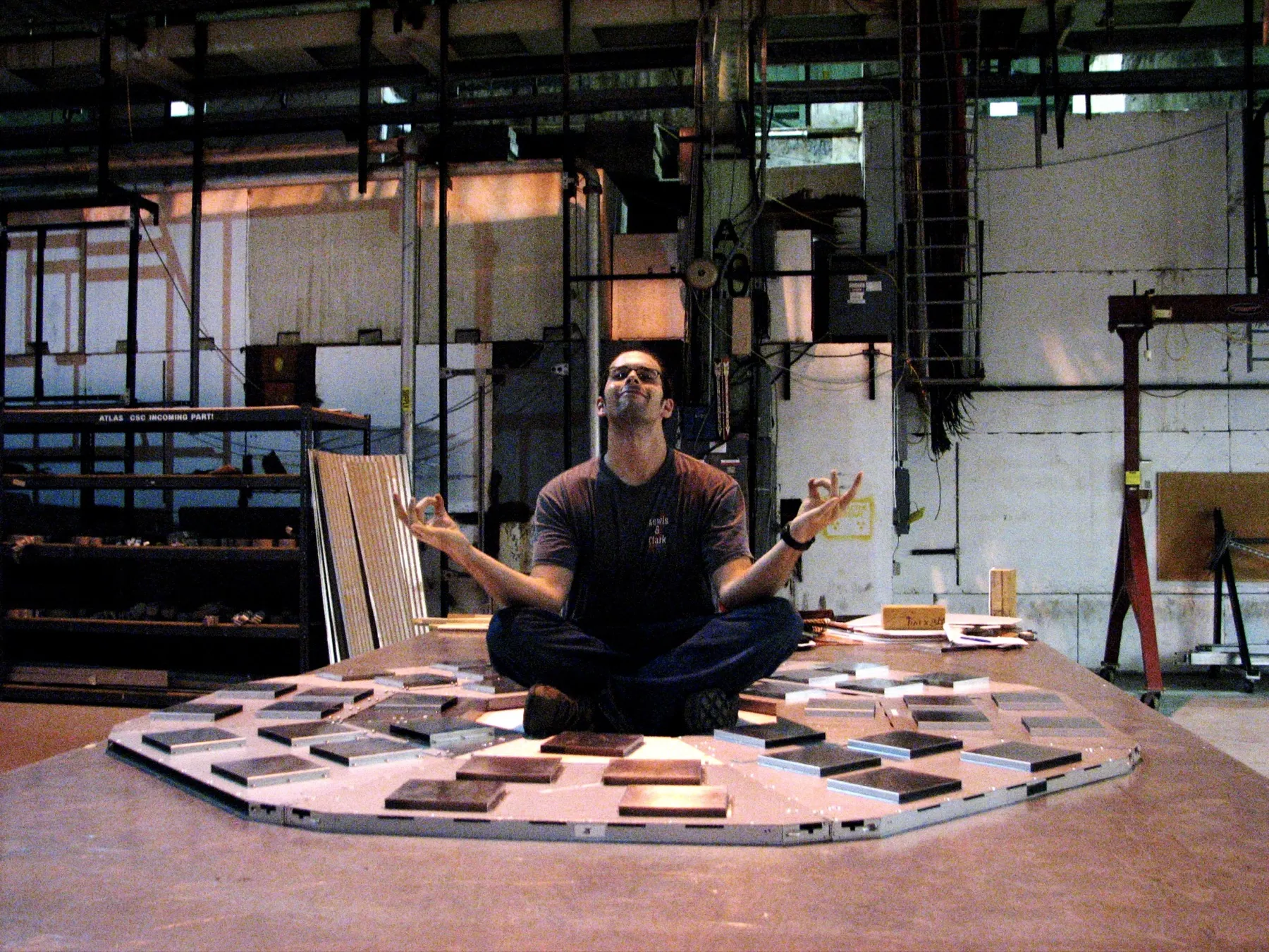 Mike sitting cross-legged, meditating, inside a resistive plate chamber under construction